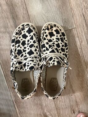Hey Dude Kids Cow-Print Slip Ons in Black & Cream